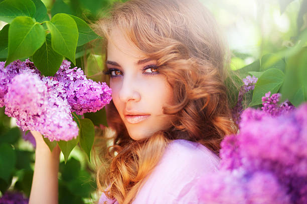 Beautiful woman in lilac blossom, in the spring