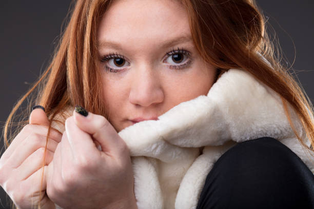 woman protecting herself from cold holding a white fur soft scarf