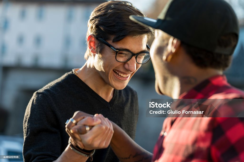 buenos amigos bromeando sobre su apretón de manos secreto - Foto de stock de Amistad libre de derechos