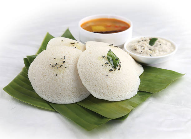 Idli with Coconut chutney and sambhar. south Indian Dish, Idli (white) on banana leaves with coconut chutney and spicy vegetable sambhar. tamil nadu stock pictures, royalty-free photos & images