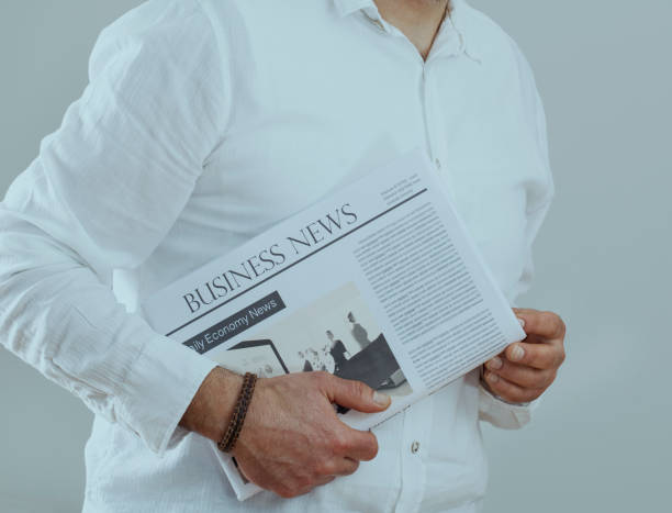 istock Businessman holding newspaper on gray background 638509234
