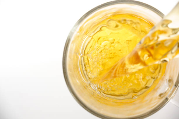 Black tea pouring into glass cup, top view