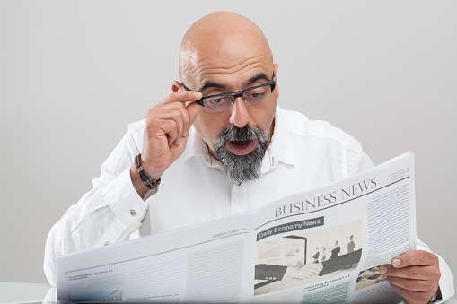 Middle aged man reading newspaper