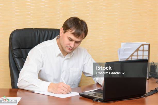 The Man At The Office Of The Table Writing On Paper Stock Photo - Download Image Now