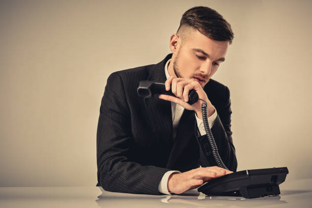 istock young man dials the phone number while sitting in the 638514012