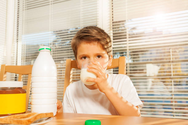 istock Little boy drinking milk at breakfast in kitchen 638516800