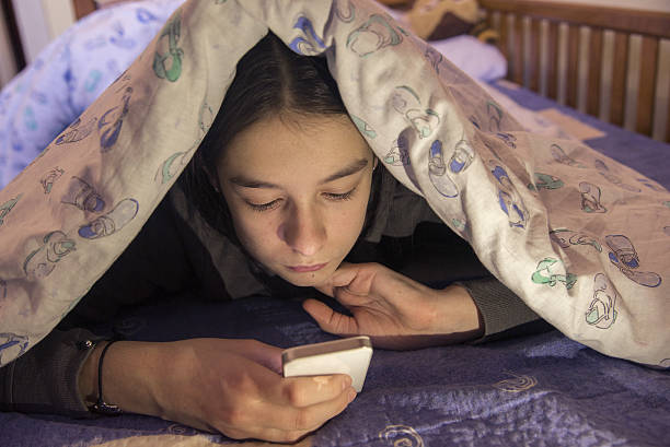 istock Teen lying on front in the bed and using smartphone 638519218