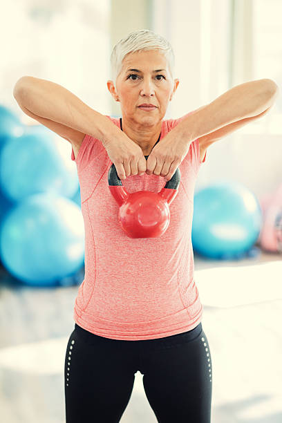 istock Mature Woman Exercising In Gym With Kettle Bell. 638520514