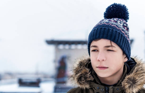 young man winter on a city street during a snowfall