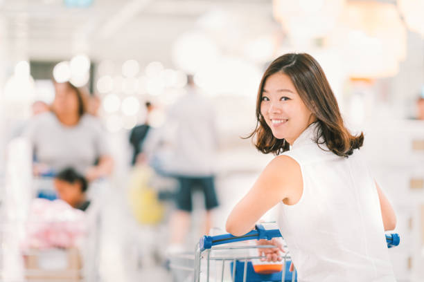 mujer asiática con carrito de compras en un centro comercial - department store shopping teenage girls clothing fotografías e imágenes de stock