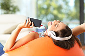 Teen listening music on a pouf
