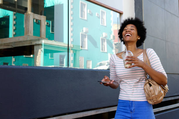 istock Laughing woman walking with coffee cup and phone 638522348