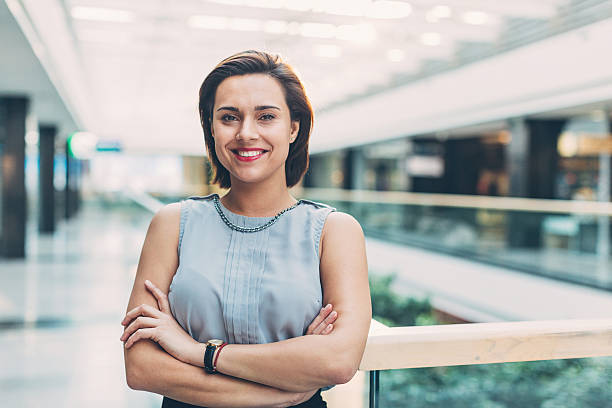 Elegant woman standing inside of business building Stylish businesswoman standing in business environment, with copy space. guru photos stock pictures, royalty-free photos & images