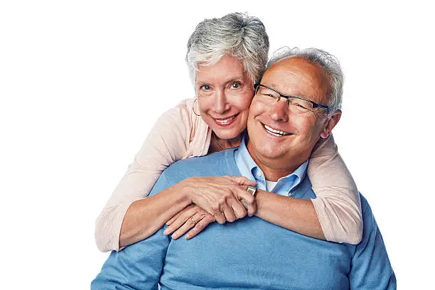 Studio portrait of a loving and happy senior couple  posing together against a white background