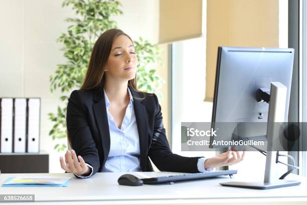 Businesswoman Relaxing Doing Yoga At Office Stock Photo - Download Image Now - Business, Freedom, Spirituality