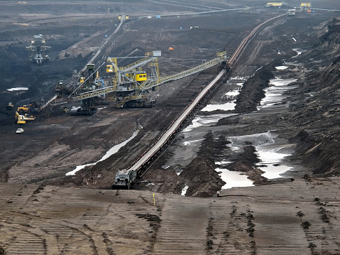view into coal mine with machines and conveyor belt.