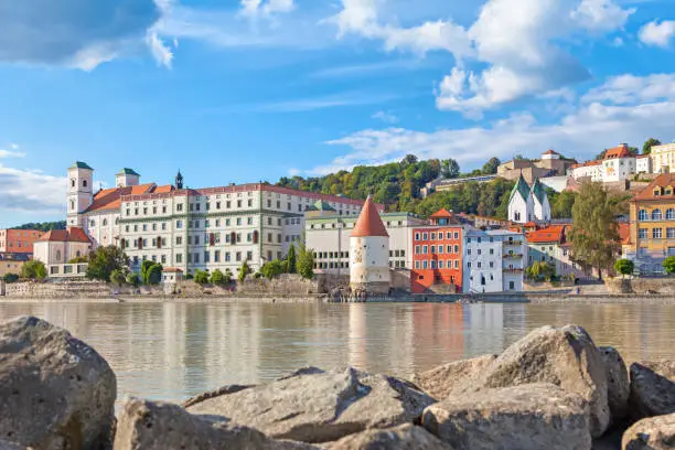 Buildings and Schaibling Tower on the side of Inn river near its confluence with Danube in Passau, Bavaria, Germany