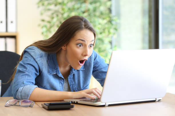 Amazed entrepreneur working on line Amazed entrepreneur working on line with a laptop at office skeptical look stock pictures, royalty-free photos & images