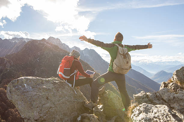 istock Two young hikers on mountain top looking at digital tablet 638537278