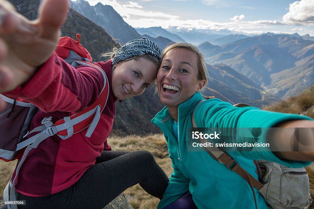 Two young women hiking take selfie portrait at mountain top Two young women hiking take a selfie portrait at the mountain top. Selfie Stock Photo