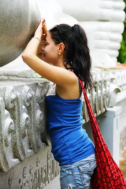 Photo of Girl at the recumbent Buddha statue makes a wish.