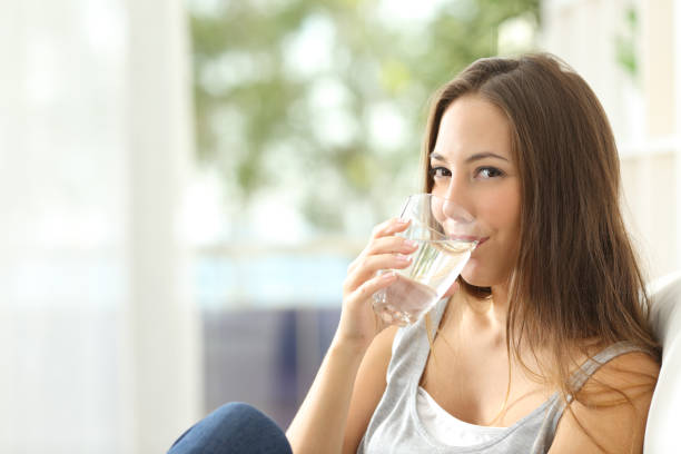 istock Woman drinking water at home and looking you 638538138