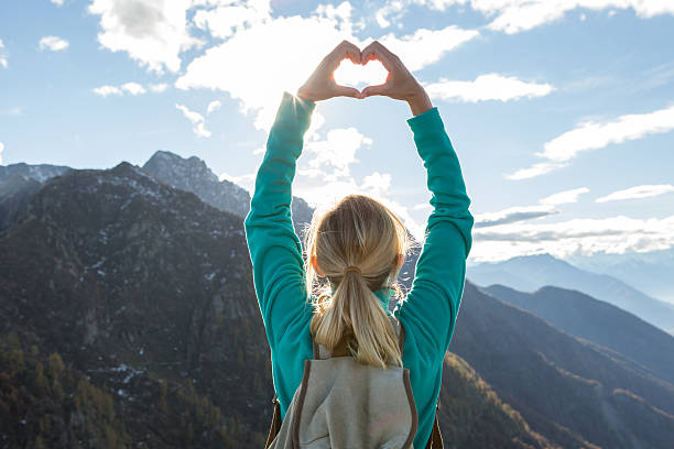 istock Young woman hiking makes heart shape finger frame 638538192