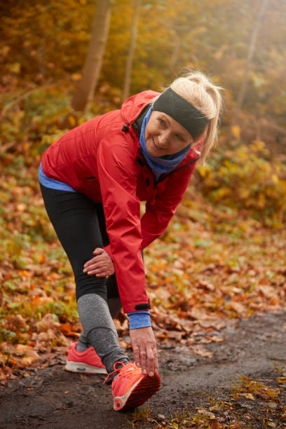 istock Senior woman stretching in public park 638538304