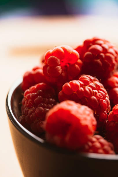 raspberry in a cup on  blurred background of wooden planks