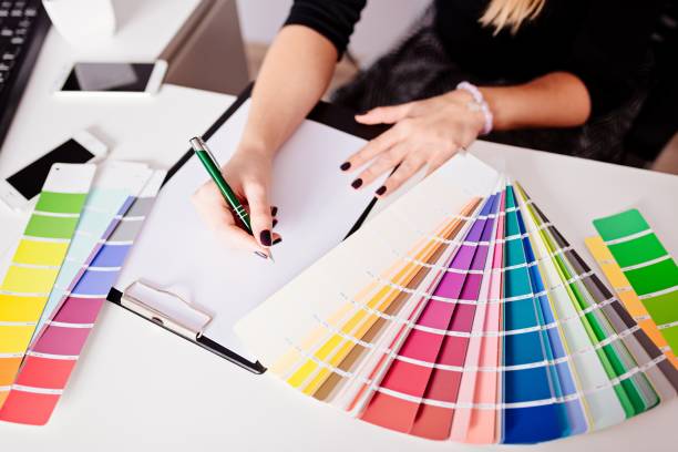 Woman designer or architect choosing color Woman designer or architect choosing color from color paletteWoman designer or architect choosing color from color palette design color swatch painting plan stock pictures, royalty-free photos & images