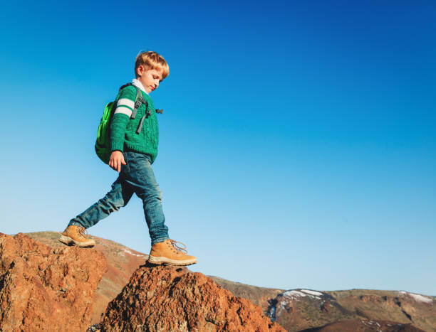 istock little boy with backpack hiking in scenic mountains 638544164