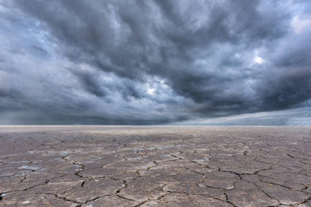 istock Soil drought cracked landscape and storm clouds background 638544686