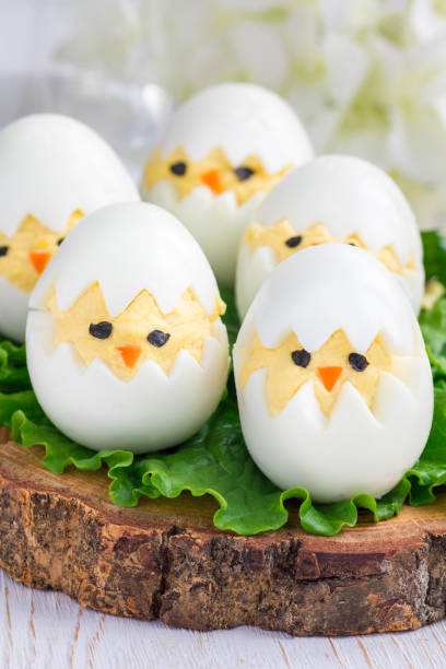 istock Little chicken in nest, deviled eggs on wooden board, vertical 638547424