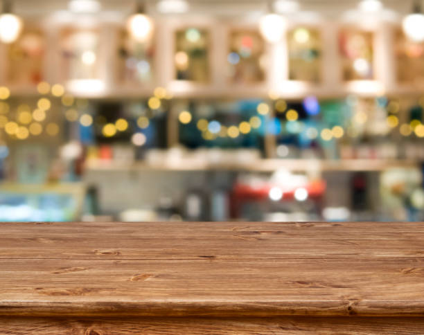Wooden table in front of abstract blurred kitchen bench background