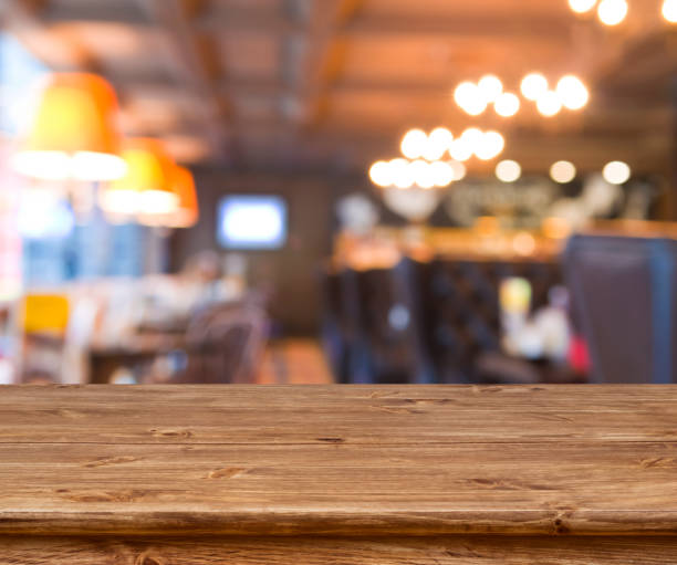 istock Wooden table in front of abstract blurred resturant lights background 638549640