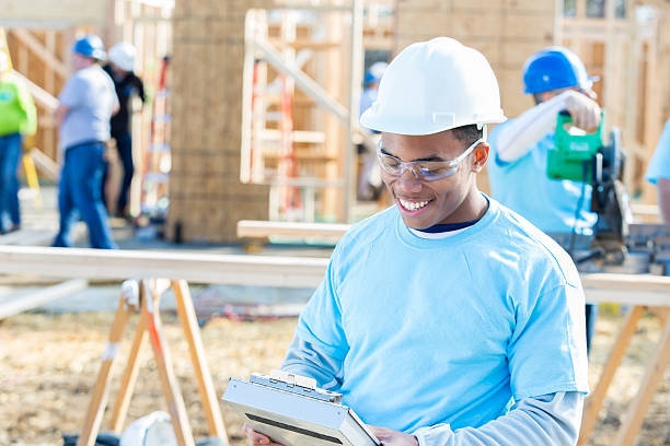 jovem capataz de construção afro-americano no local de trabalho - construction frame wood accuracy adult - fotografias e filmes do acervo