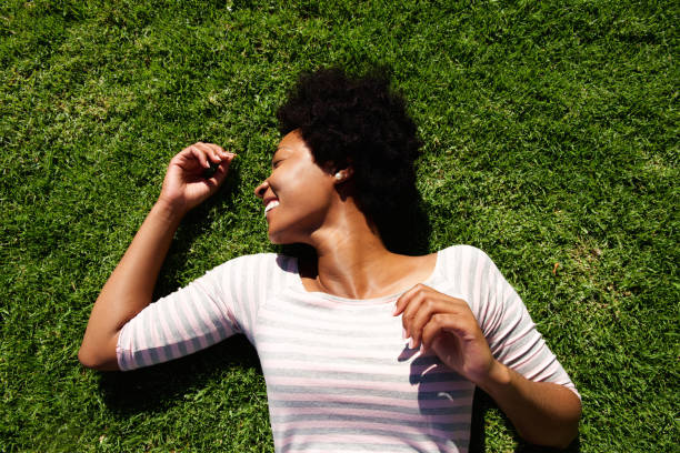 istock Laughing woman lying in grass in the summer 638553346
