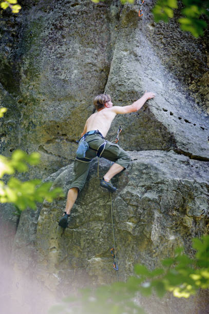istock Muscular rock climber climbs on cliff wall with rope 638554584