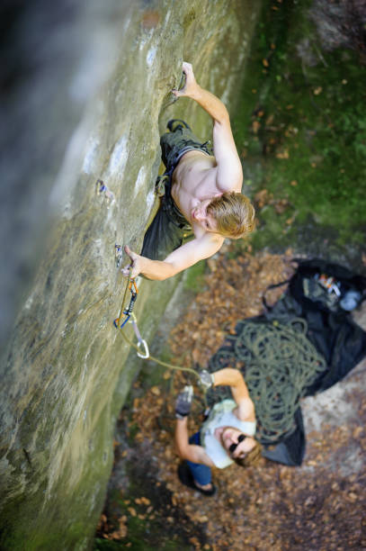 istock Muscular rock climber climbs on cliff wall with rope 638554696