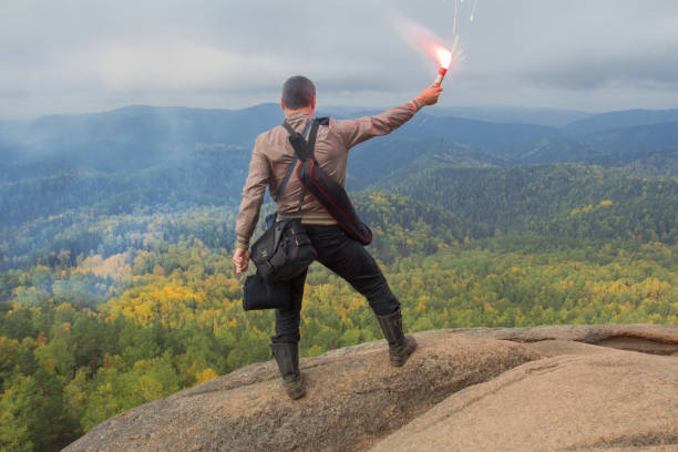 istock Man with a Flare on a Mountain Top 638555632