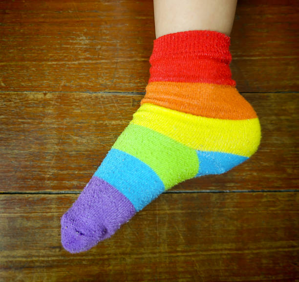 istock Rainbow Multicolor Sock on child feed on wooden floor. 638556428