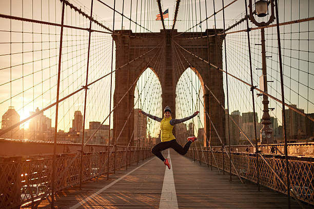 спортсменка прыгает на мосту - footpath lower manhattan horizontal new york city стоковые фото и изображения