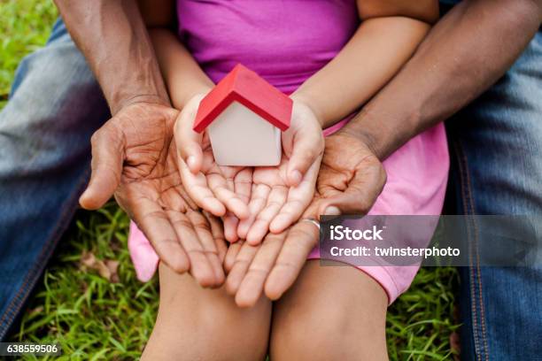 Hands Of Family Together Holding House In Green Park Stock Photo - Download Image Now