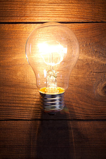istock Vintage incandescent bulb on old wooden table 638562578