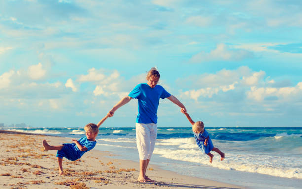 istock happy father with son and daughter play at beach 638563576