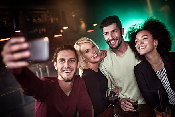 istock Group of young people in the bar taking a selfie 638563676