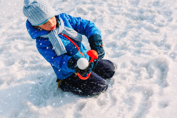 istock little boy making snowball in winter nature 638564978