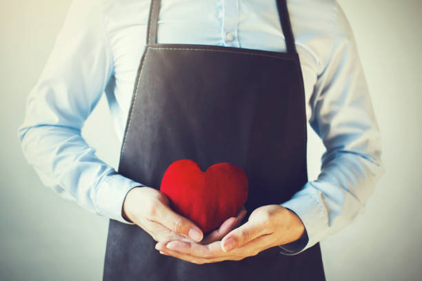 istock Servicing man in apron holding open armed heart with hands 638565520