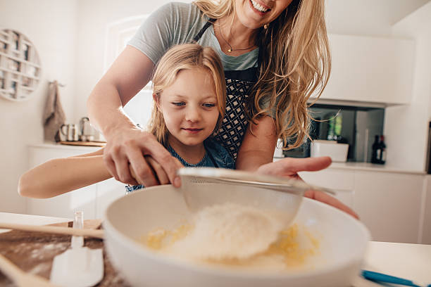 istock Little girl learning to make batter from her mother 638567438
