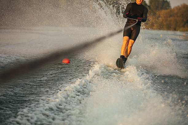 istock Man riding wakeboard on wave of motorboat 638567750
